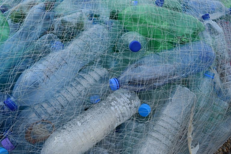 Sticle de plastic adunate intr-o plasa de pescuit