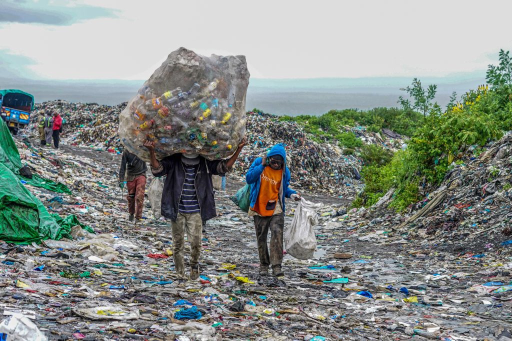 Lucrători la groapa de gunoi Gioto din Nakuru, Kenya, transportă materiale plastice pentru reciclare.(Credit foto: James Wakibia/SOPA Images/LightRocket via Getty Images).